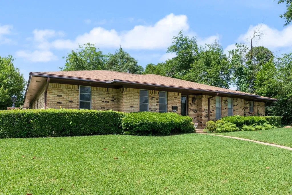 Brick exterior with a brown shingle roof