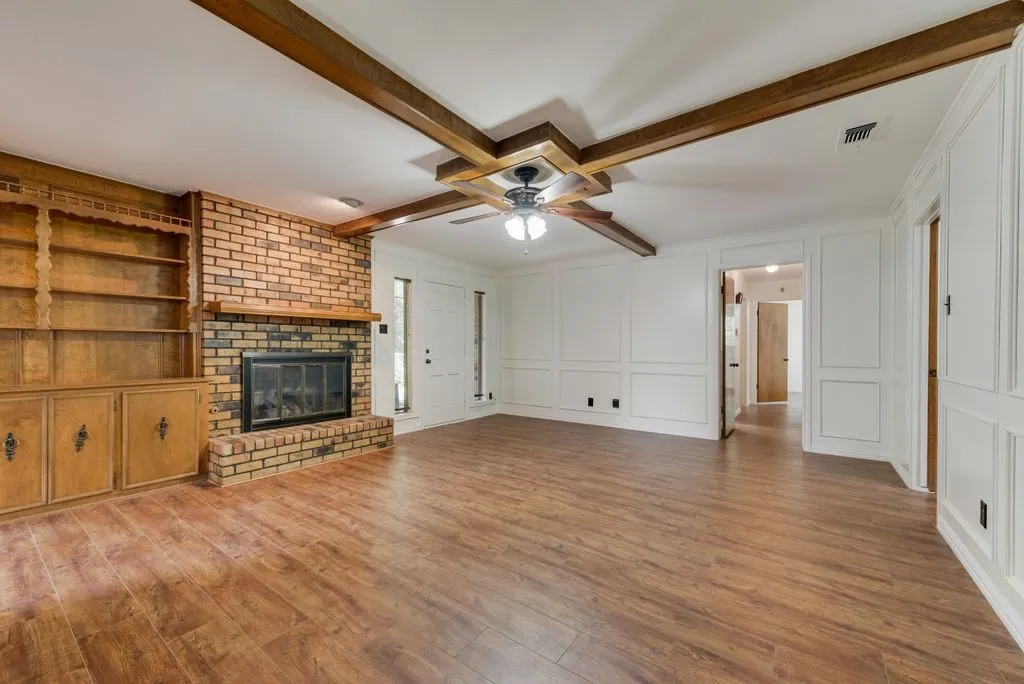 Spacious interior featuring wood-finish flooring and a brick fireplace