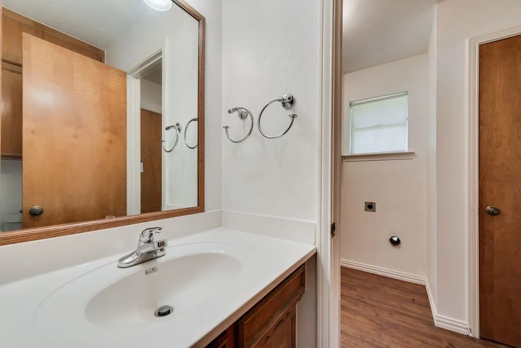 Bathroom vanity featuring a white countertop with an integrated sink and chrome faucet