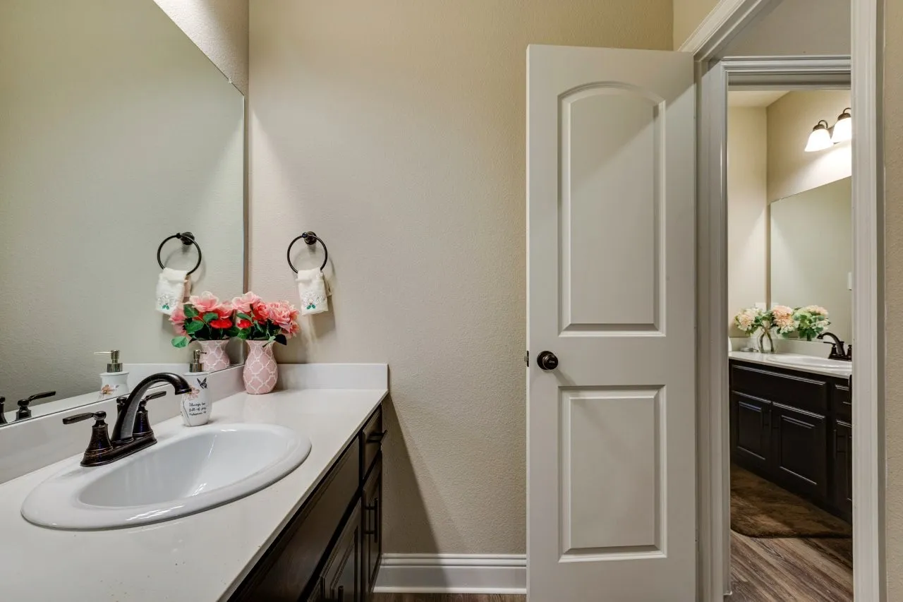 White solid-surface countertop with an integrated oval sink and an oil-rubbed bronze faucet