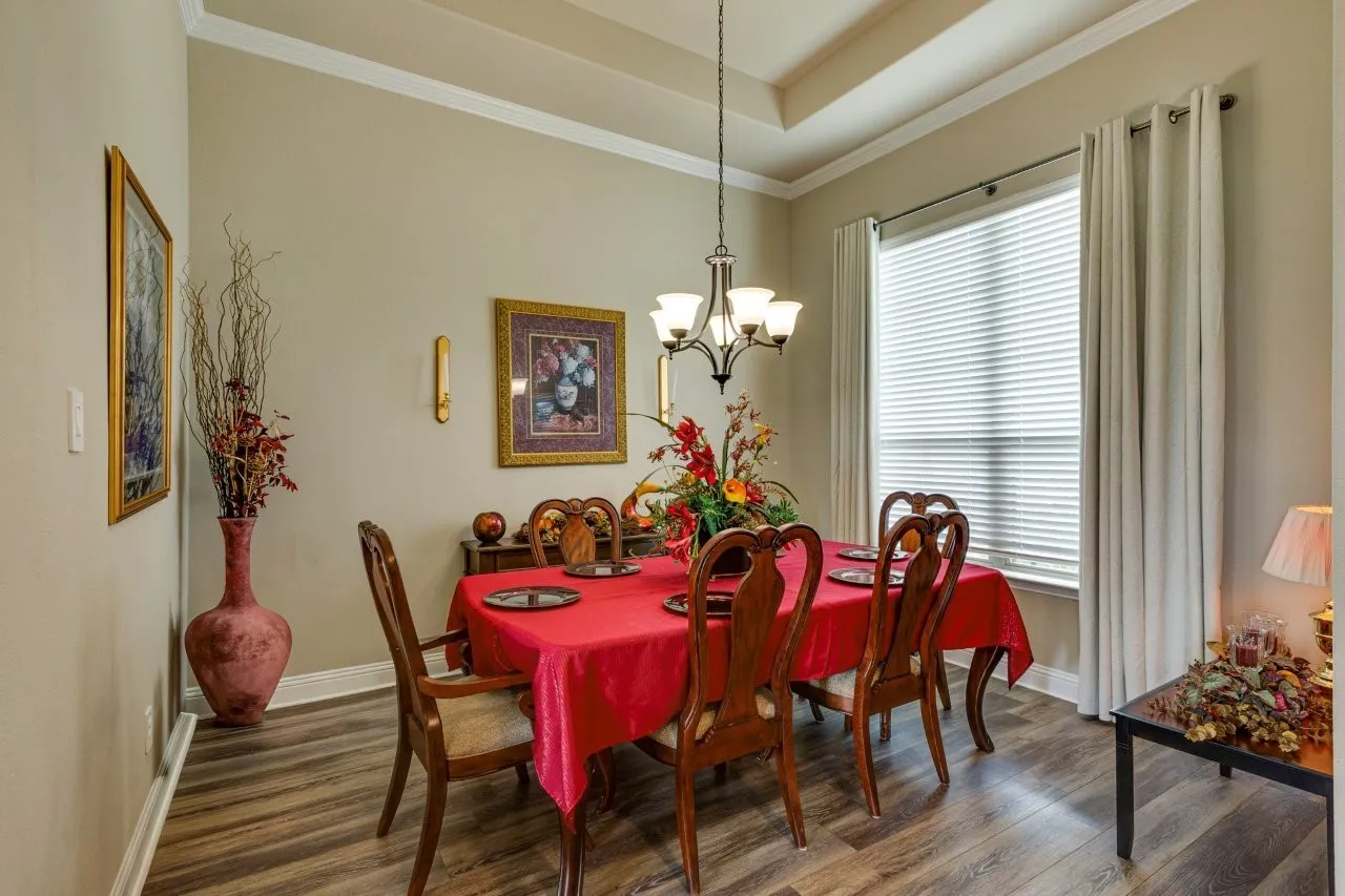 Dining area featuring wood-finish flooring, a tray ceiling, and crown molding