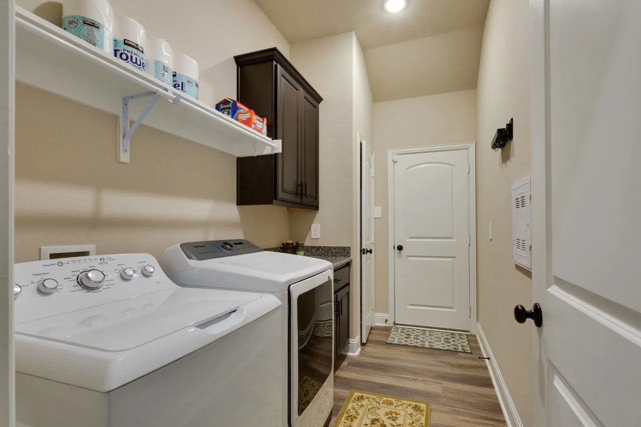Dedicated laundry room featuring wood-finish flooring, light-toned walls, and recessed lighting