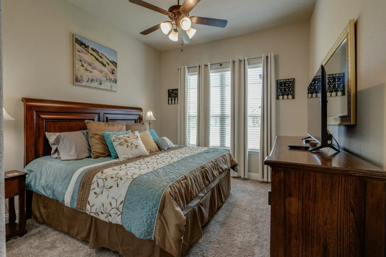 Neutral wall paint tones, recessed lighting, and a ceiling fan with integrated lighting
