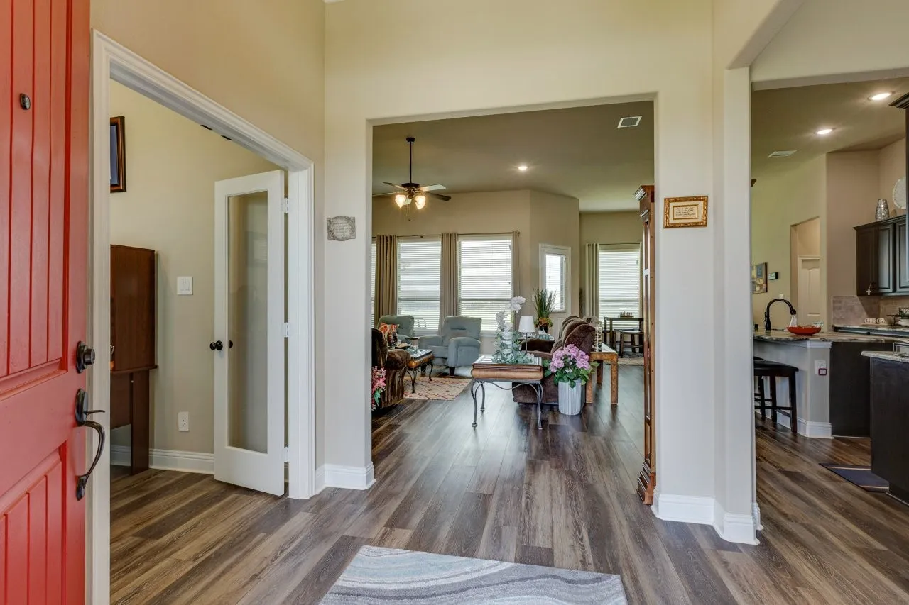 Entryway with wood-finish flooring extending into the open-concept living area and kitchen