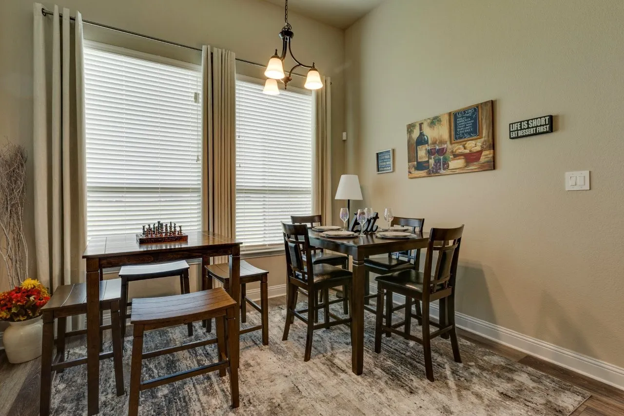 Dining area featuring multiple windows with blinds, a chandelier light fixture, and wood-finish flooring