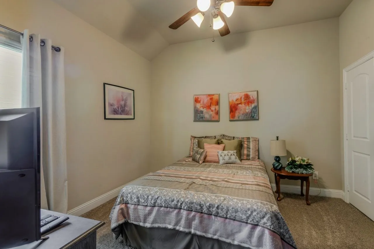 Carpeted room with a ceiling fan light fixture