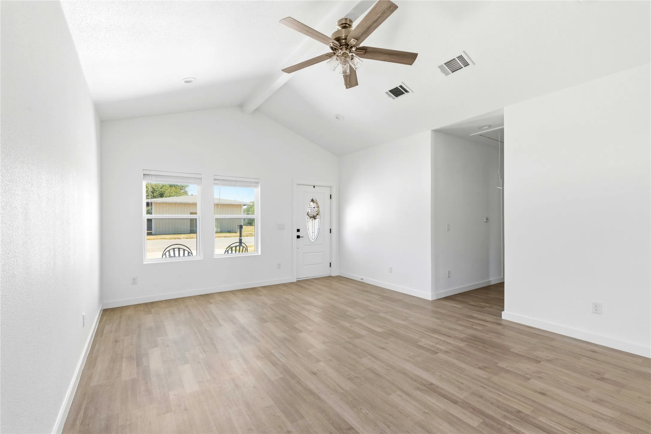 Contemporary kitchen featuring white cabinetry, light countertops, wood-finish flooring, and stainless steel appliances
