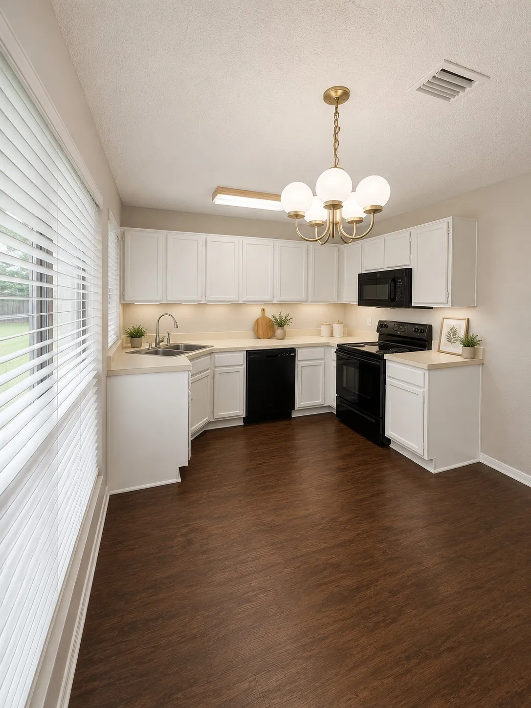 Kitchen featuring white cabinetry, light countertops, and black appliances