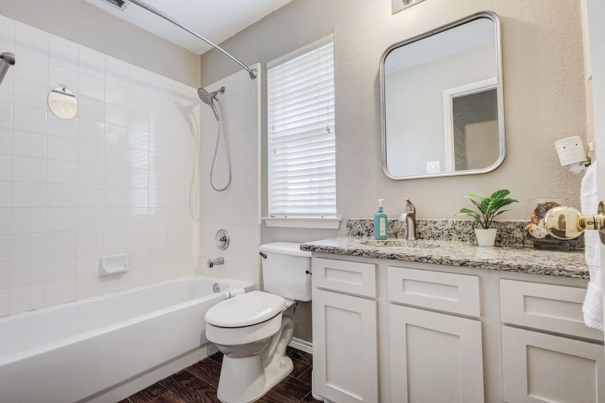 Bathroom featuring a white vanity with panel cabinetry and a speckled countertop