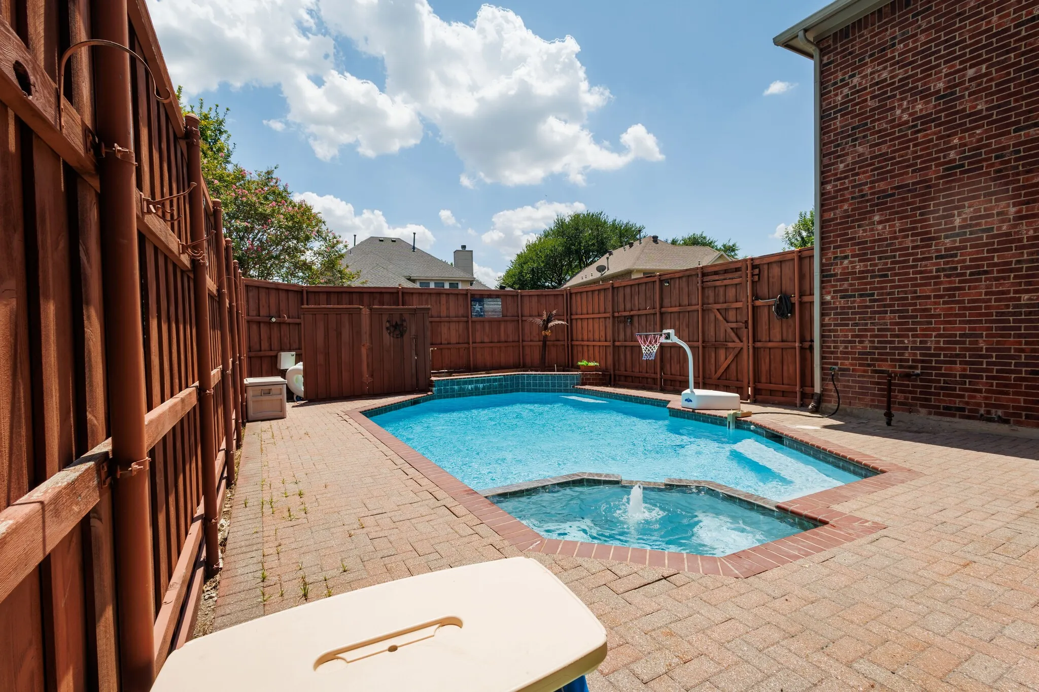 Backyard featuring a rectangular swimming pool with integrated spa and fountain