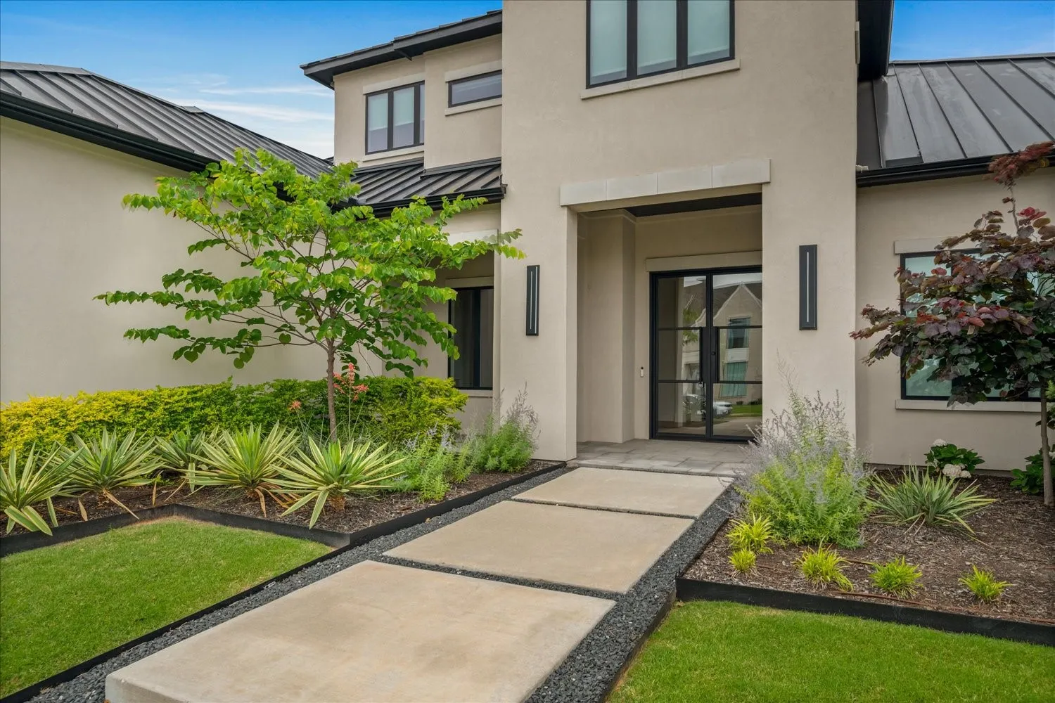 Modern stucco exterior with black metal roof