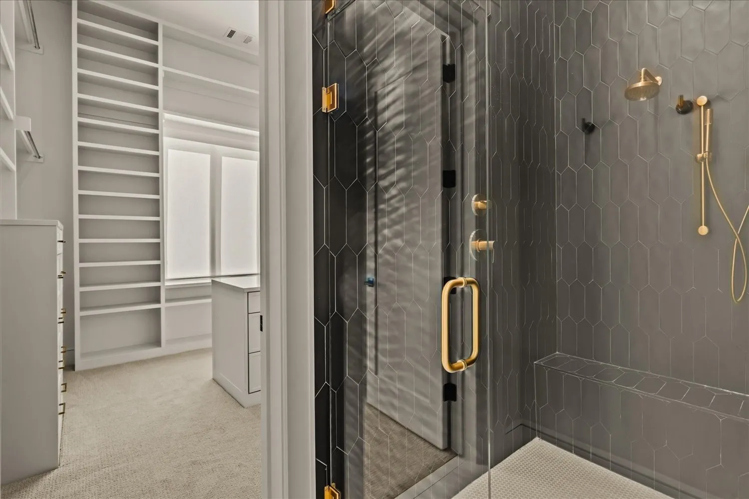 Walk-in shower with gold-finish fixtures and dark grey picket tile