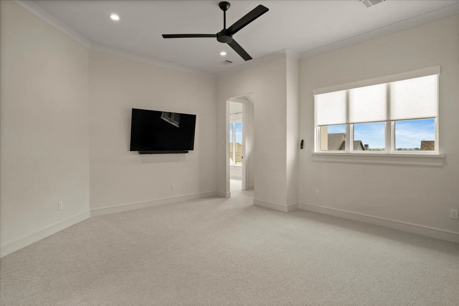 Spacious room with light-toned wall-to-wall carpeting and neutral wall paint