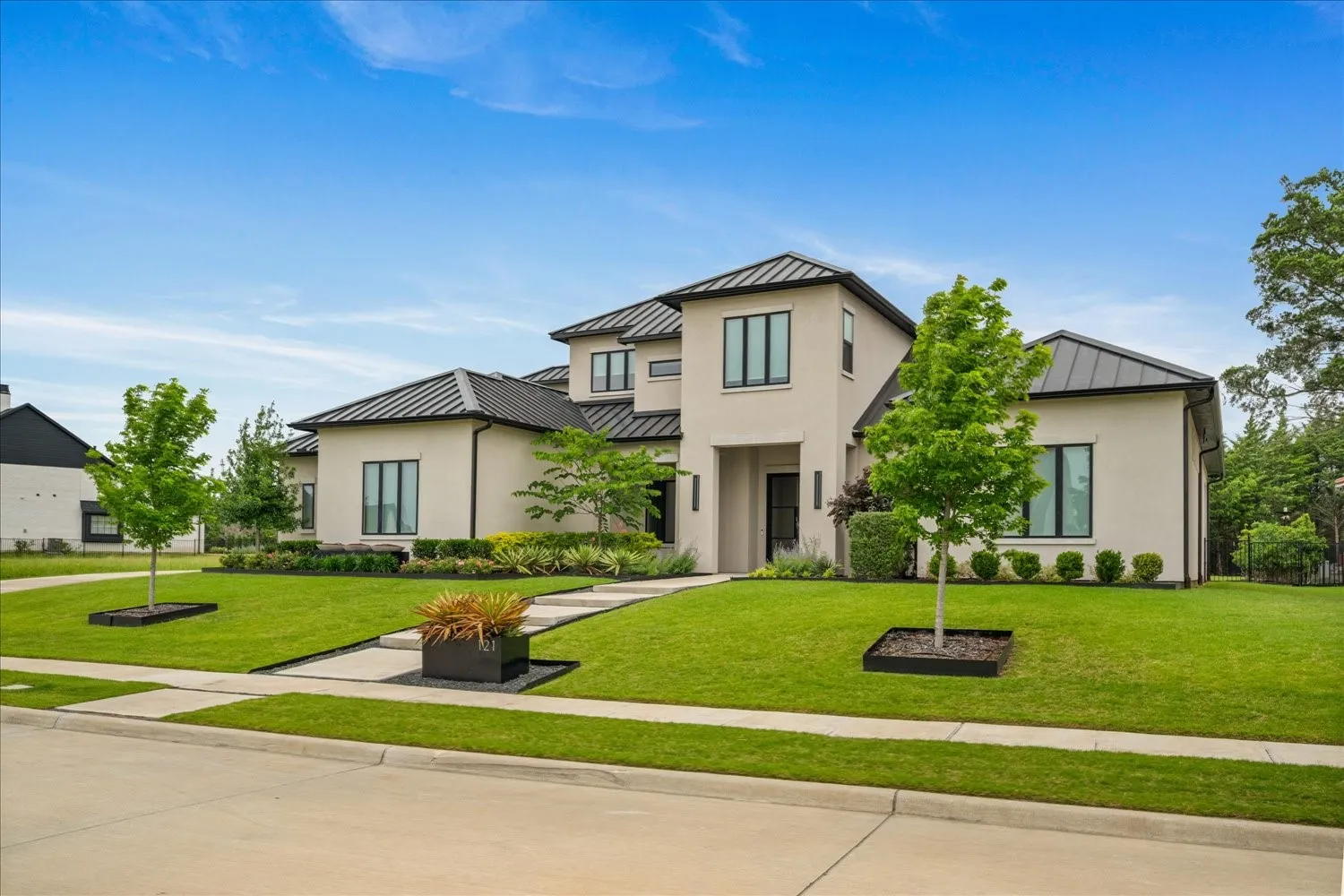 Contemporary stucco exterior with dark metal roofing