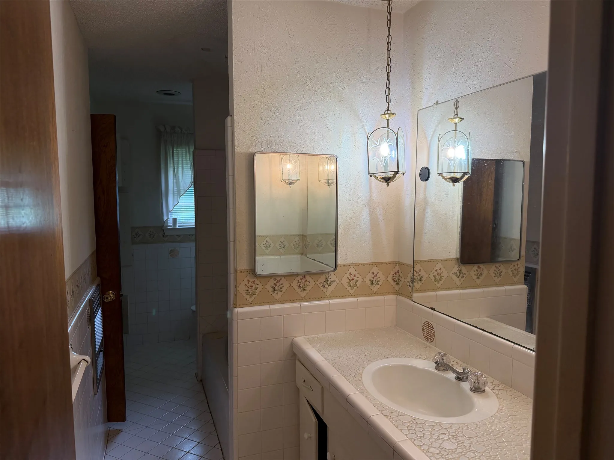 Bathroom vanity featuring a mosaic-style countertop and integrated sink basin