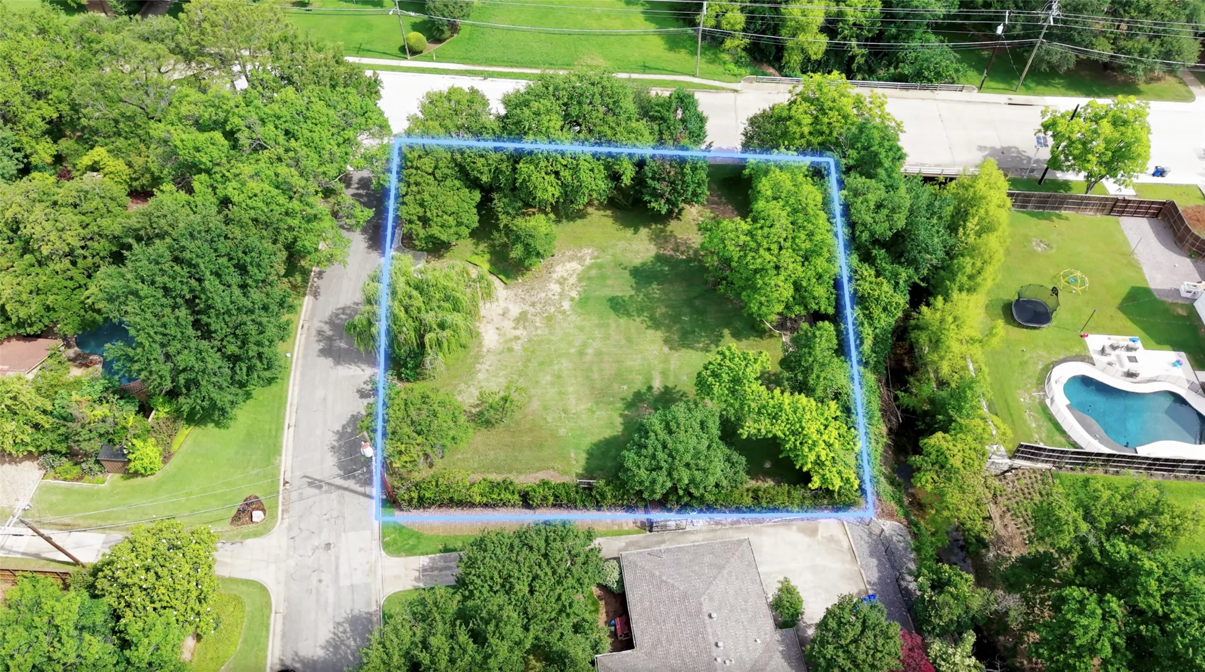 Expansive lot featuring mature trees and a substantial grassy area
