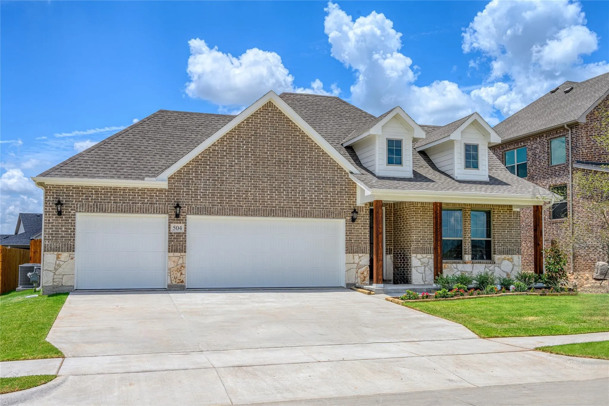 View of front facade with 3 car garage, central AC, and a front lawn
