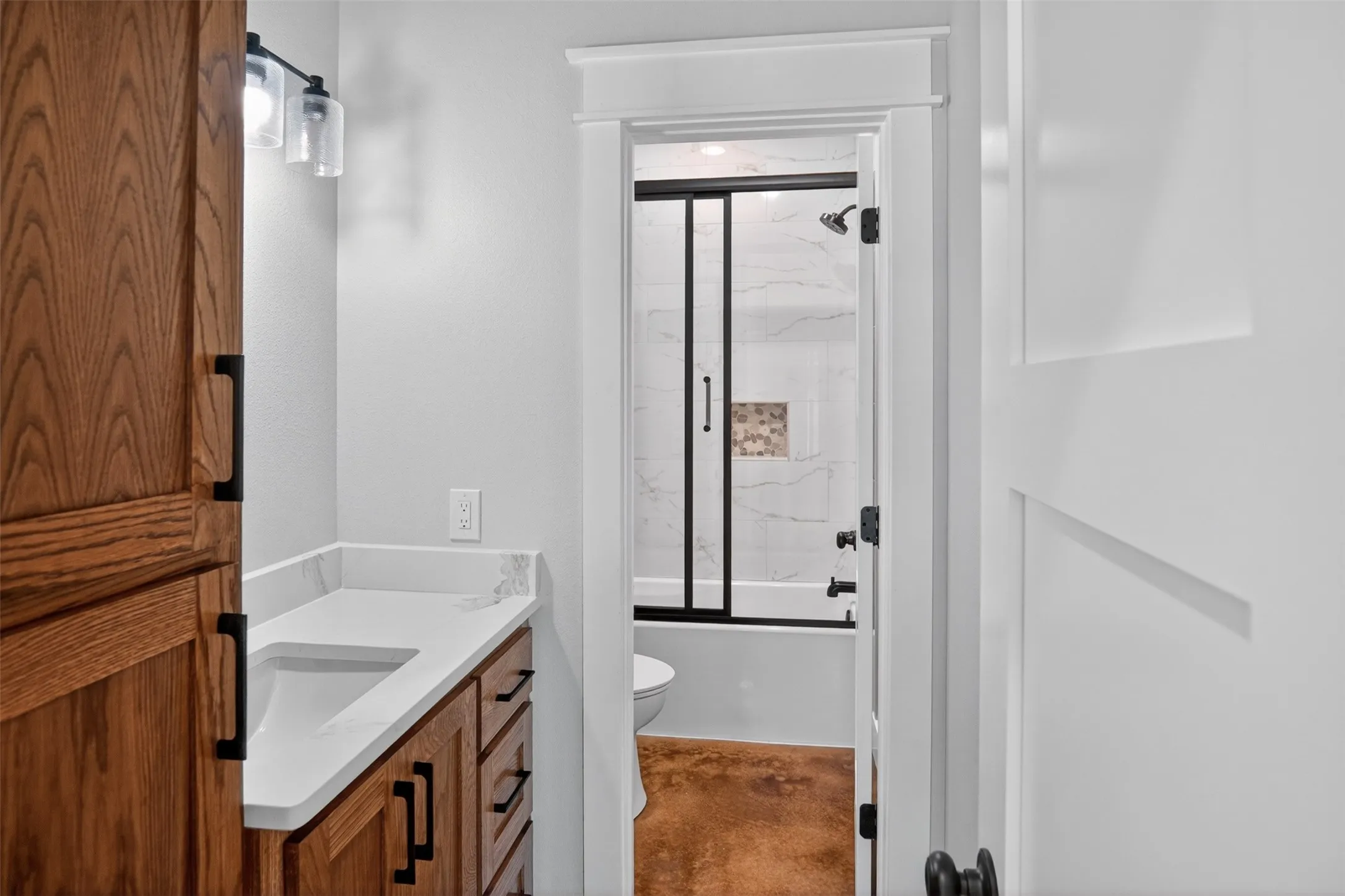 Full Bathroom featuring a wood-finish vanity with a built-in sink and solid surface countertop