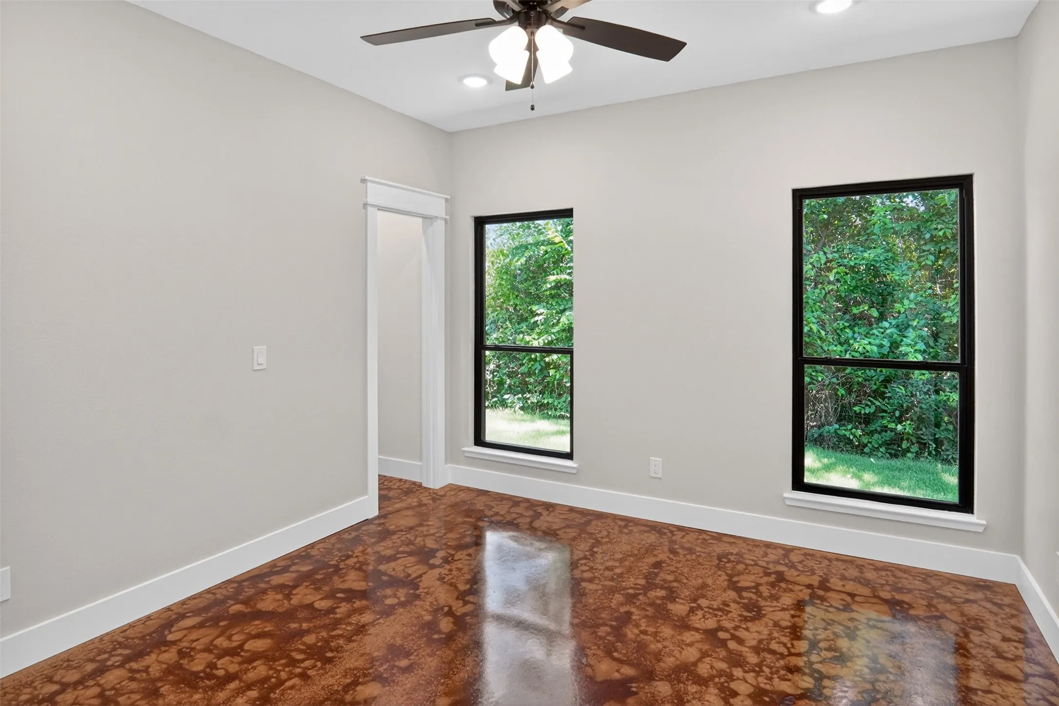 2nd primary Spacious room featuring patterned flooring, two large windows, a ceiling fan with integrated lighting, recessed lighting, and crisp white baseboards