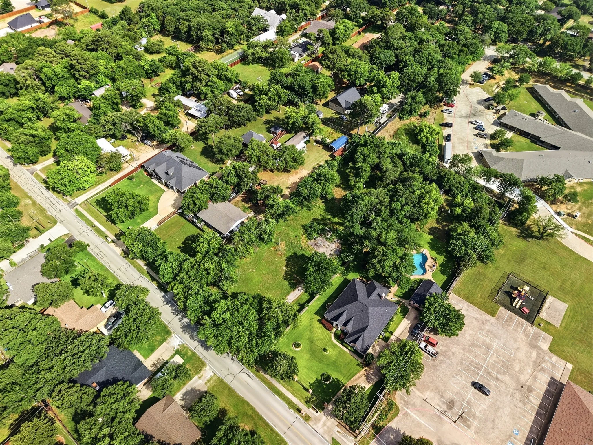 Aerial perspective showcasing the established neighborhood with custom homes and extensive tree canopy and privacy