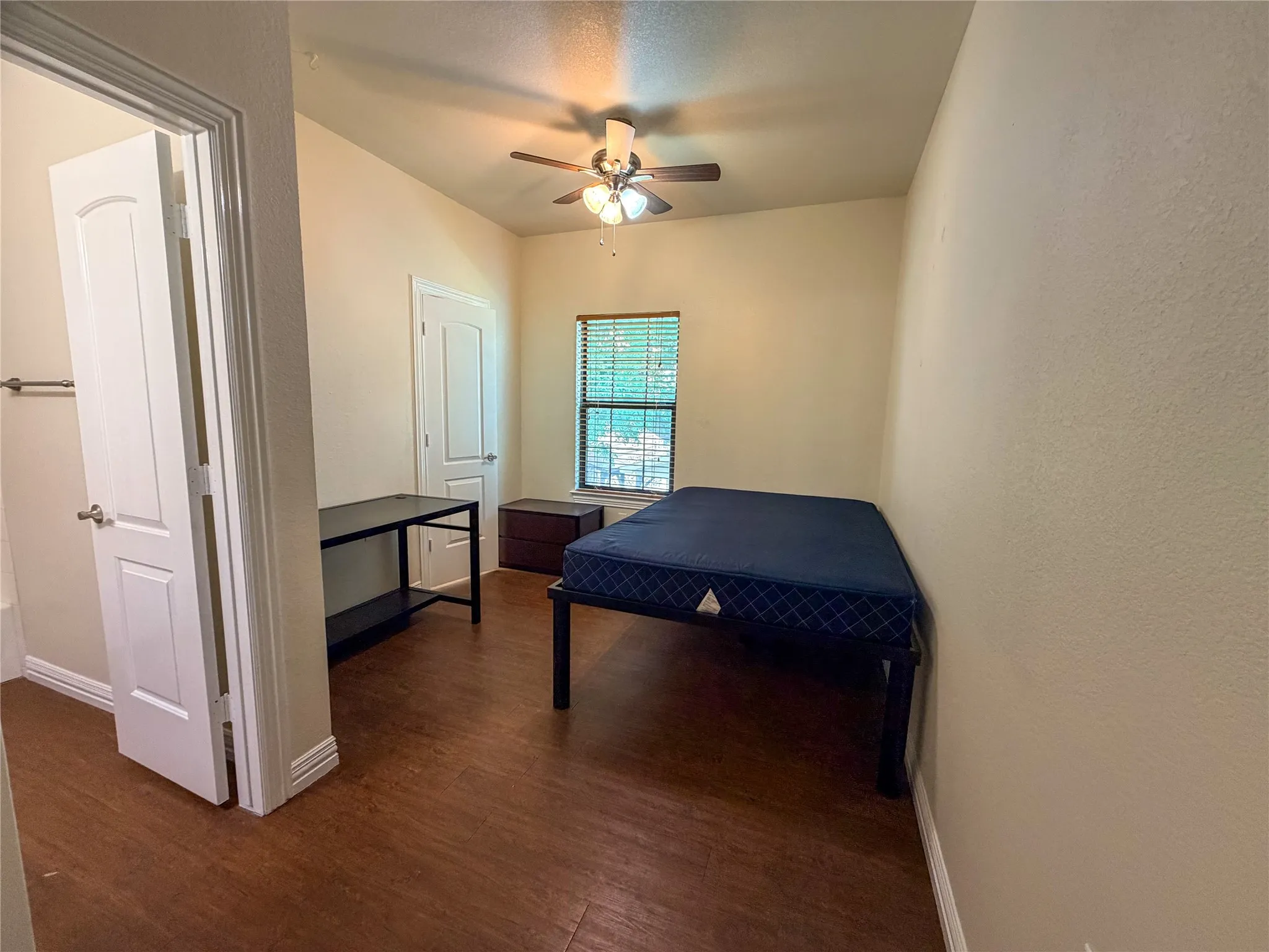 Bedroom 4: featuring wood-finish flooring, a window with blinds, a ceiling fan with light fixture, and a white interior door