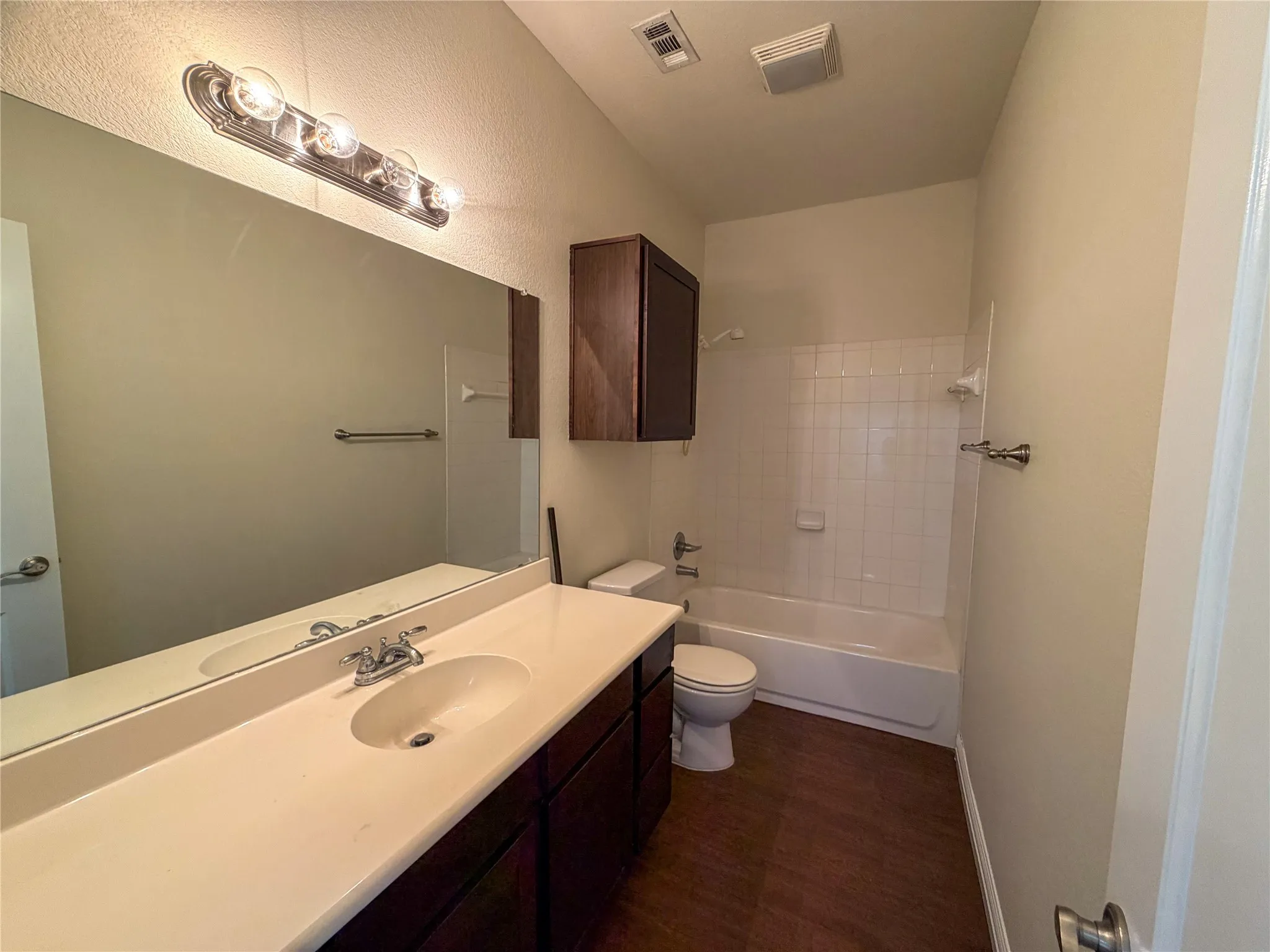 Bathroom 5: featuring a vanity with a light-toned countertop, integrated sink, and dark wood-finish cabinetry