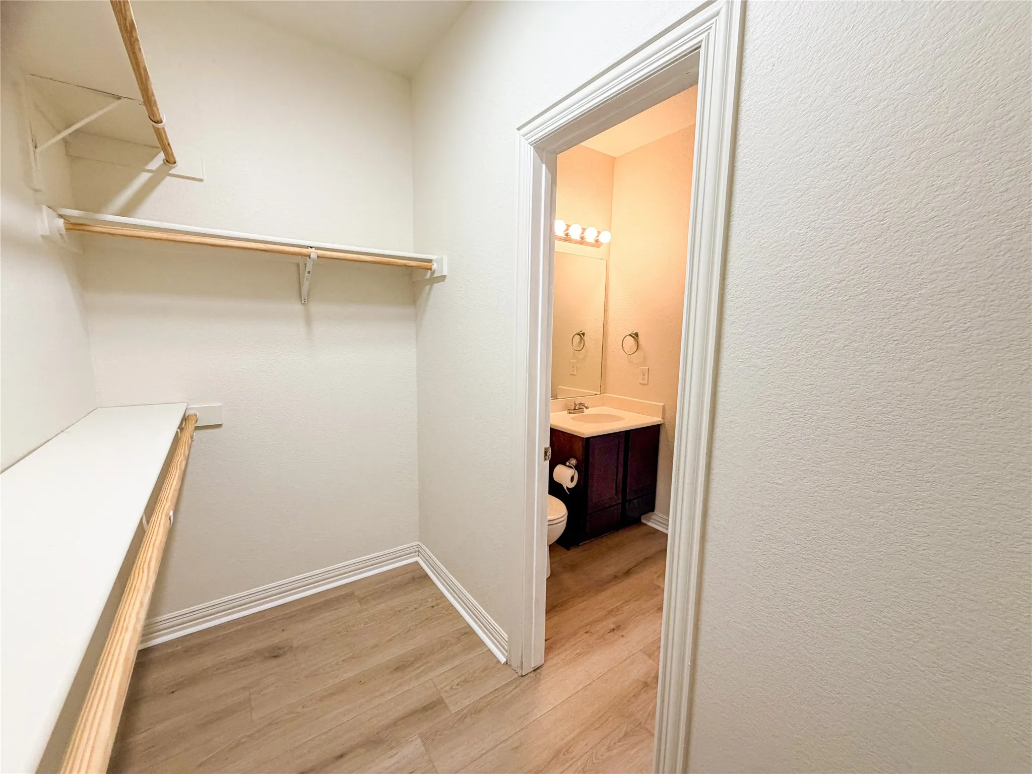 Walk-in closet with built-in shelving and hanging rods