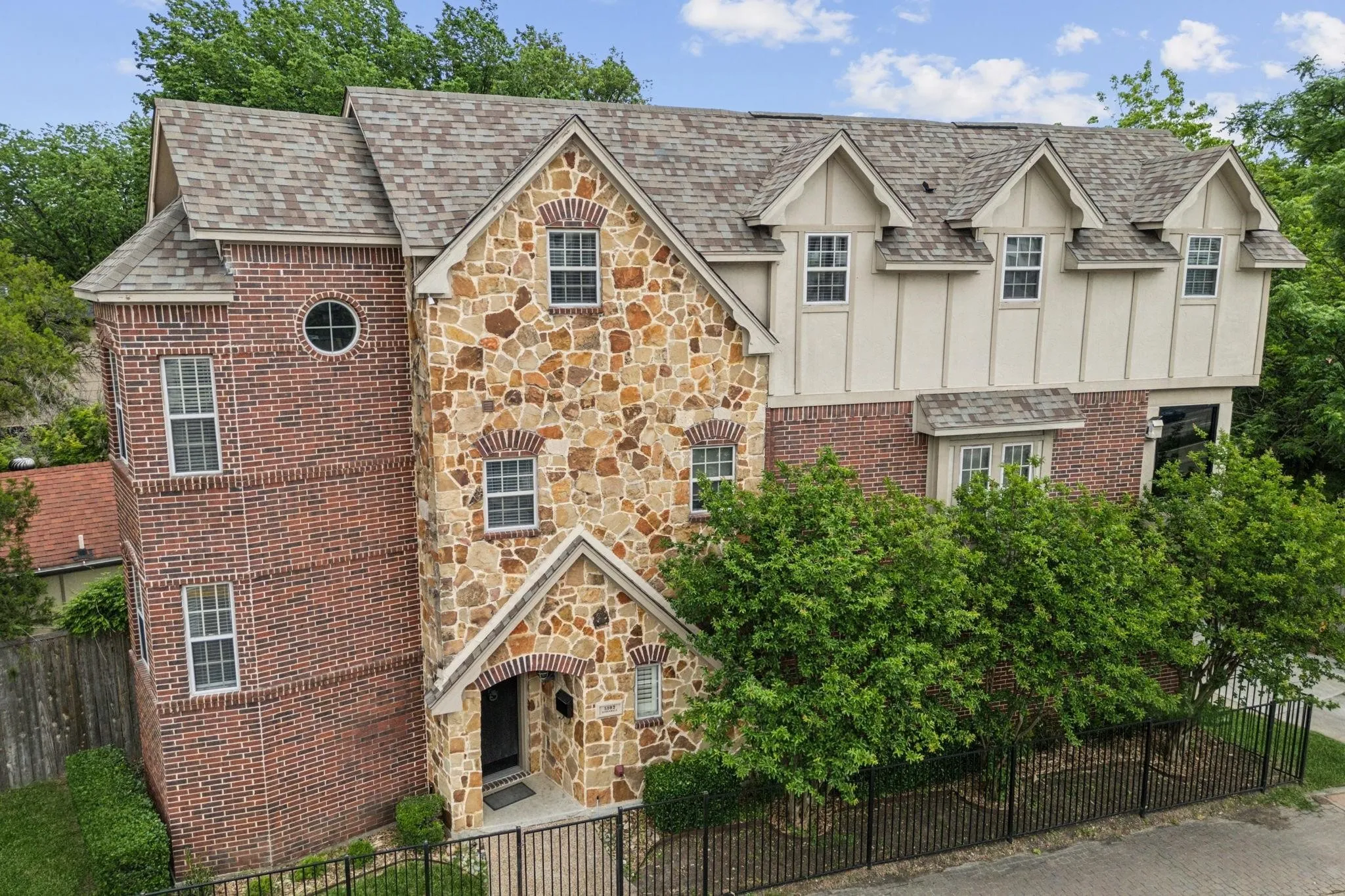 Multi-story facade featuring a prominent stone and brick exterior