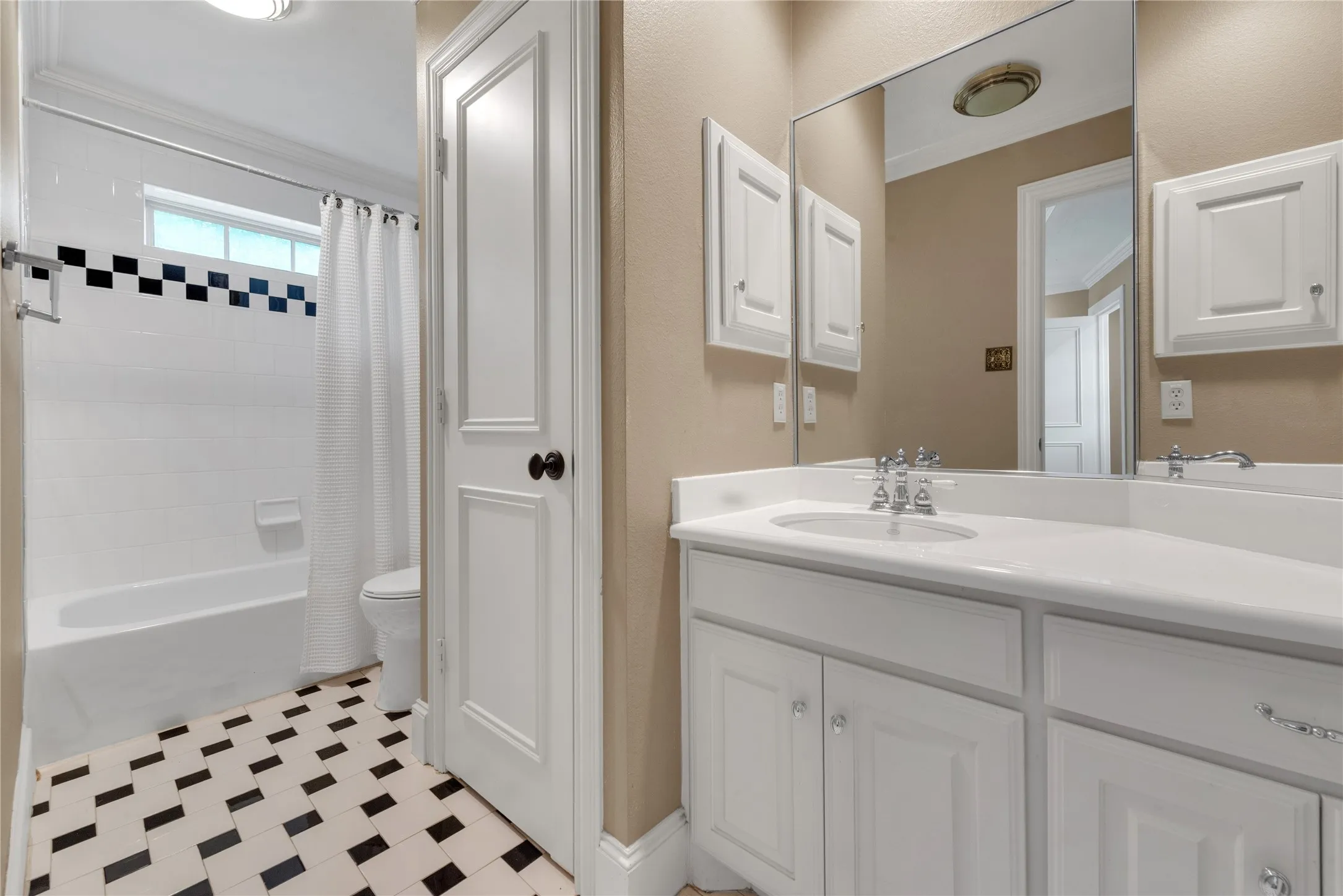 Bathroom featuring a white vanity with an integrated sink, polished chrome faucet, and a large mirror