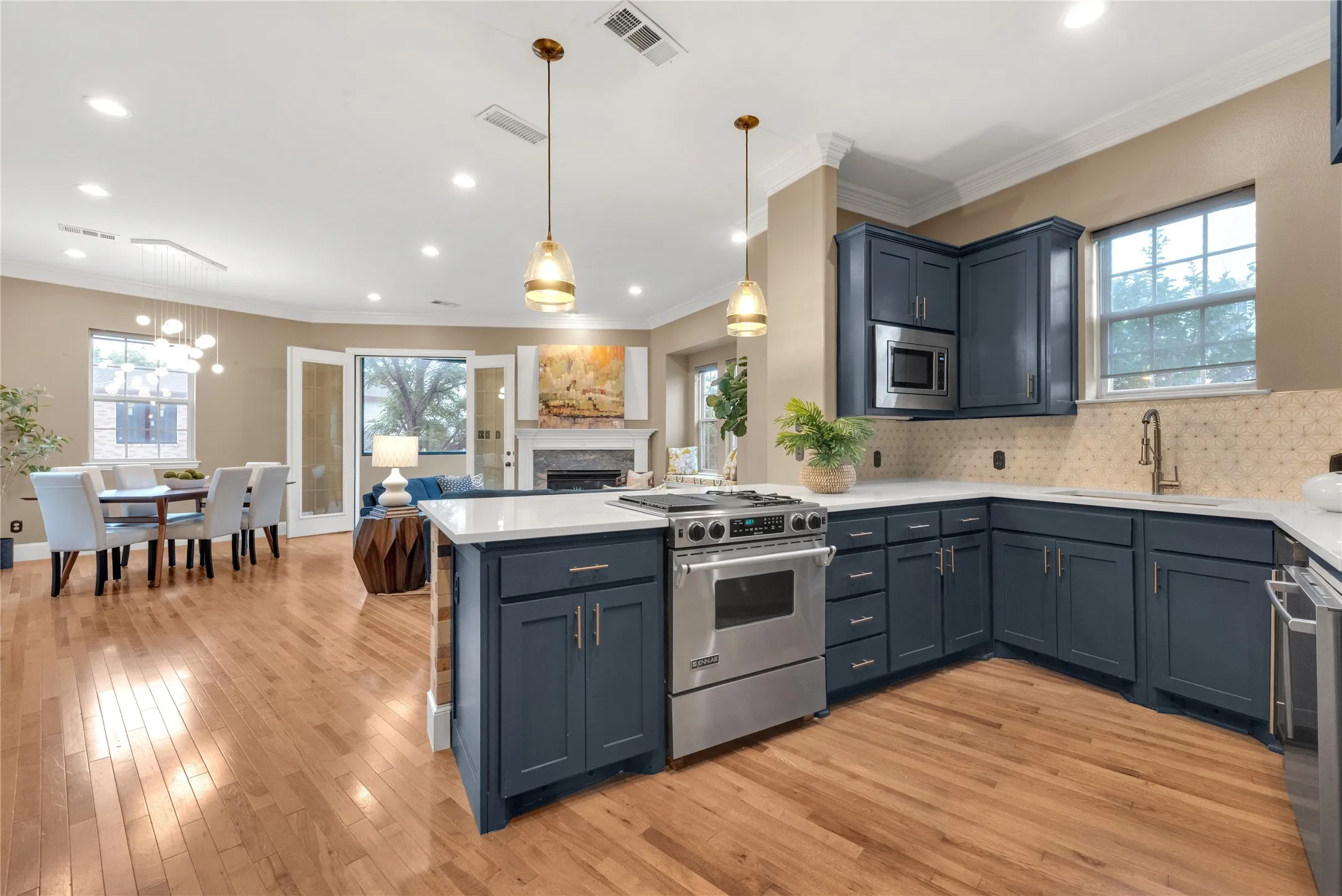 Open-concept kitchen featuring shaker-style cabinetry, a built-in microwave, and stainless steel appliances
