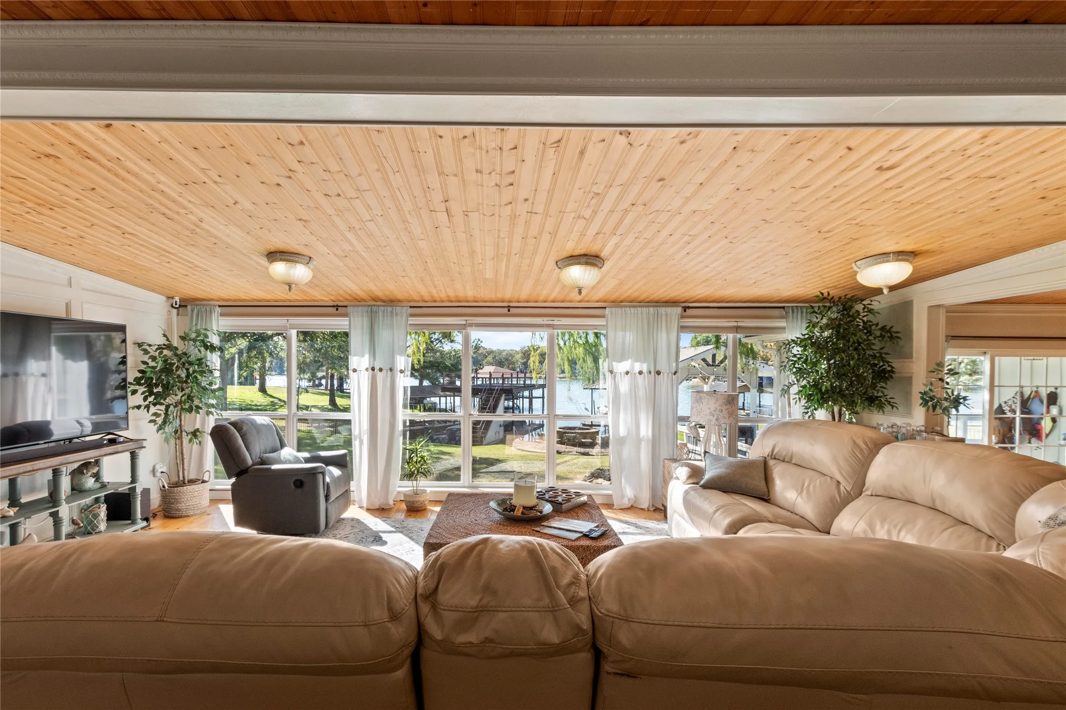 Spacious living room featuring expansive windows overlooking the water