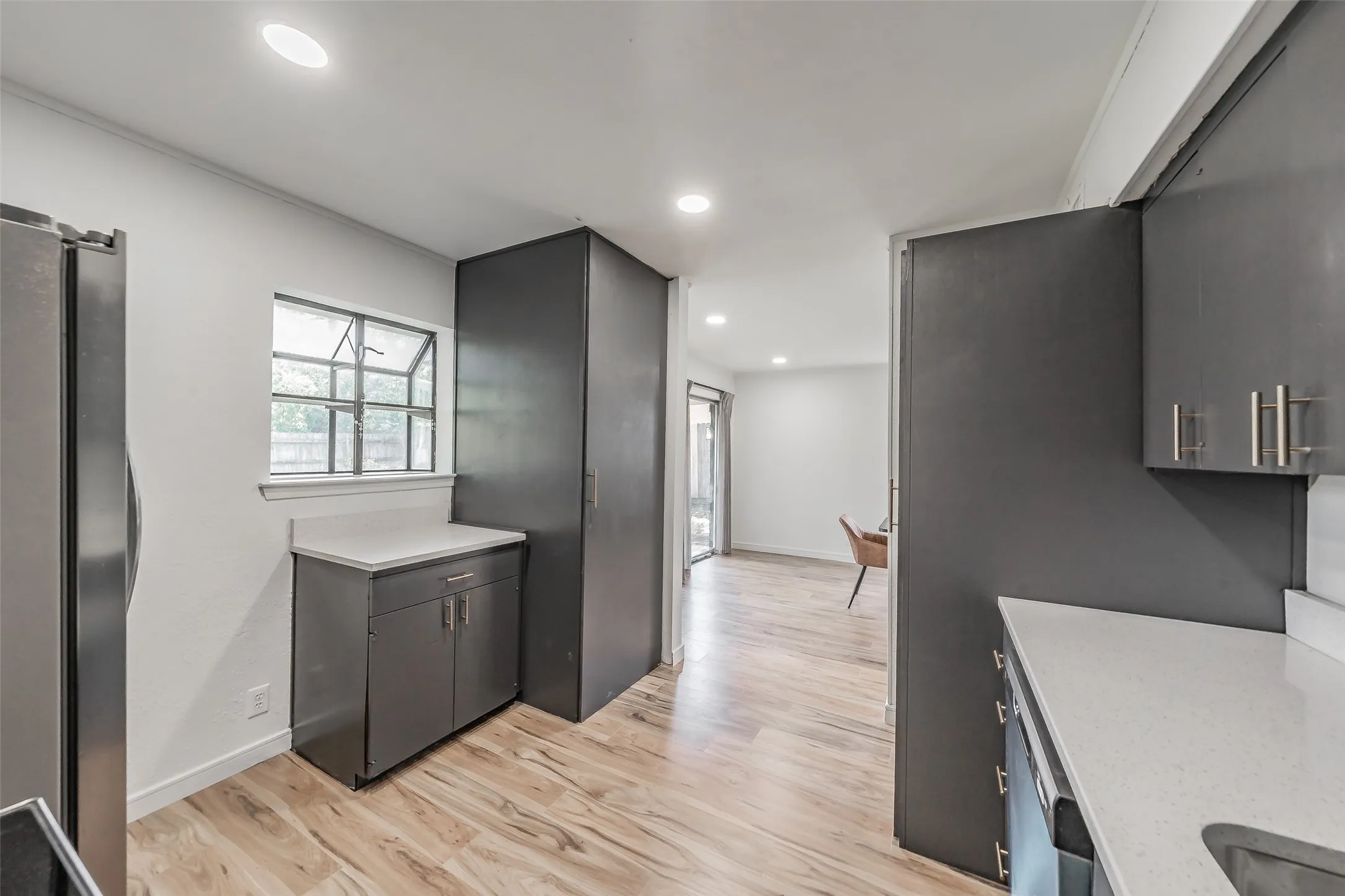 Kitchen featuring wood-finish flooring, recessed lighting, and a window with grid detailing