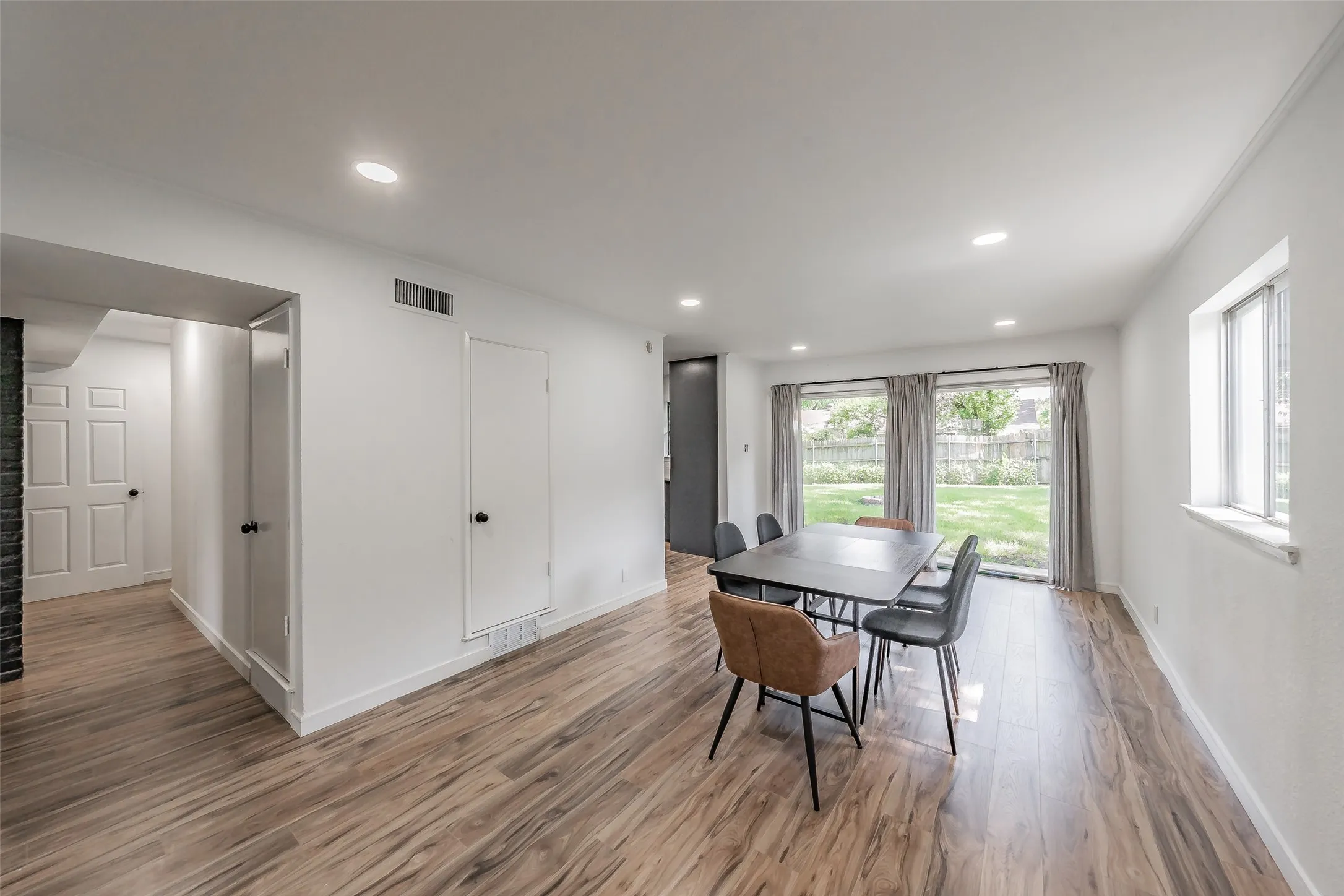 Open-concept living area featuring wood-finish flooring, recessed lighting, and white baseboards