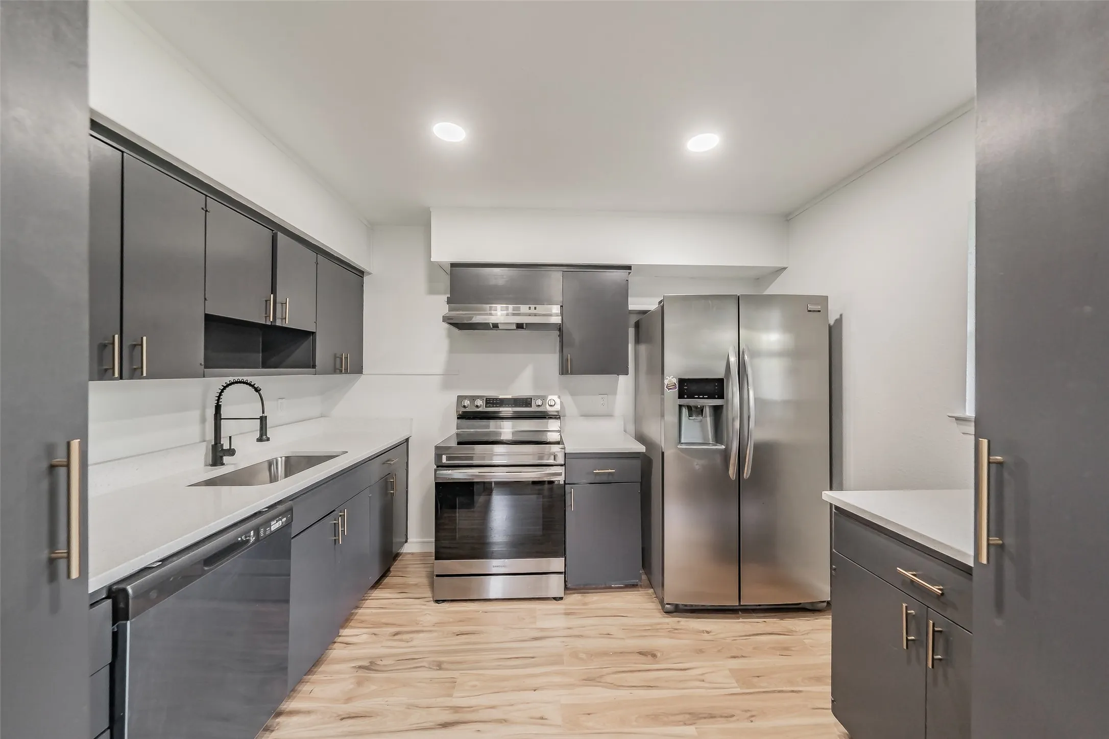 Kitchen featuring gray cabinetry, light countertops, and stainless steel appliances