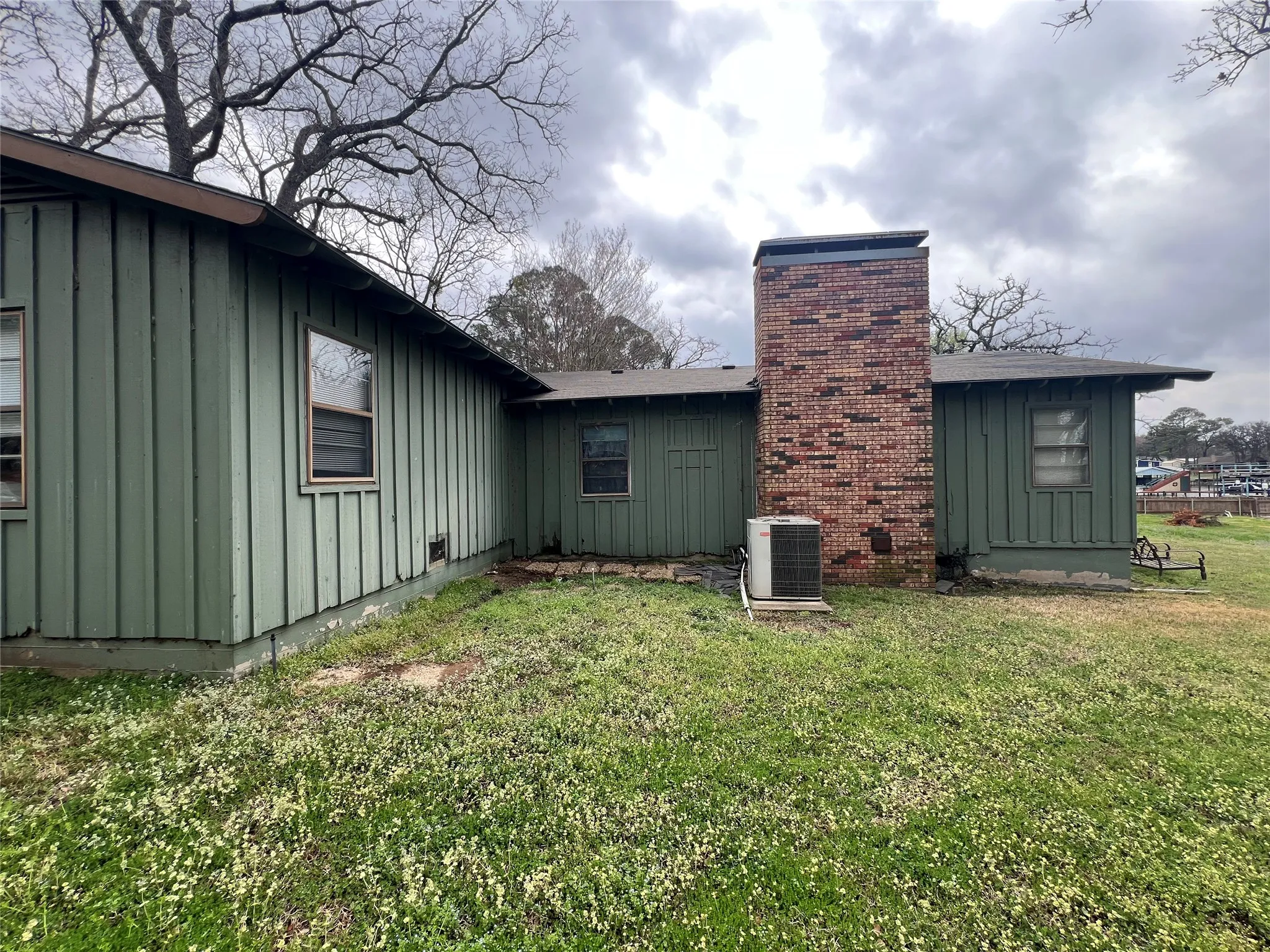 Property exterior featuring board and batten siding, a brick chimney
