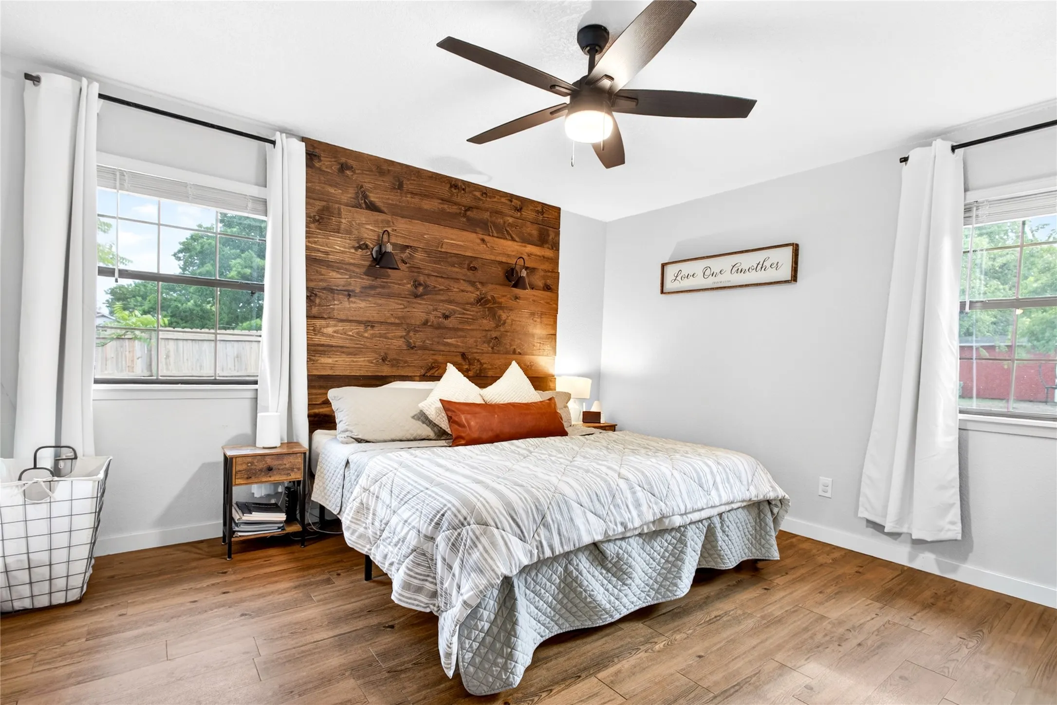 Bedroom featuring a wood-panel accent wall and wood-finish flooring