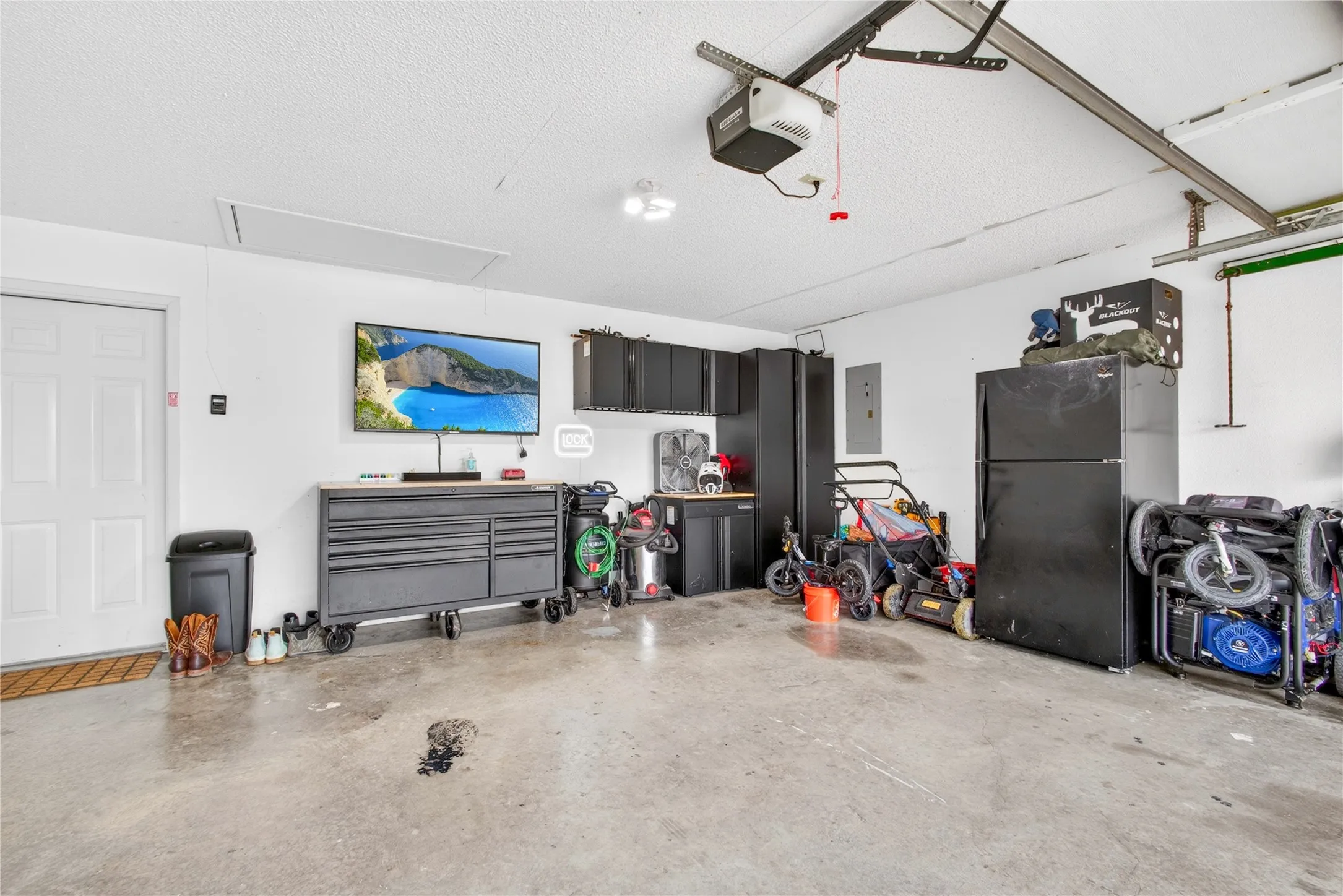 Spacious garage featuring concrete flooring and a white paneled entry door