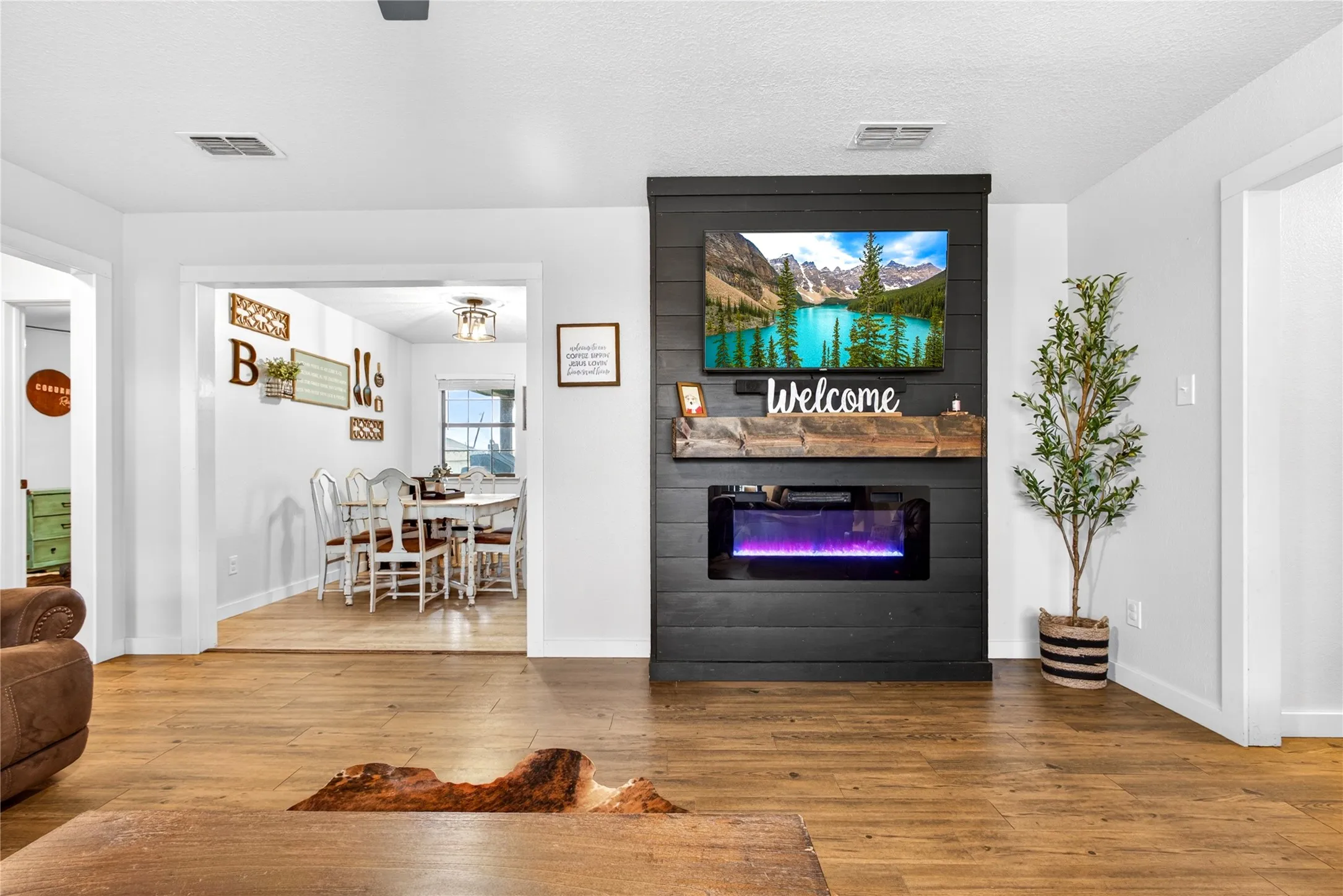 Living area featuring wood-finish flooring and a contemporary fireplace with an integrated media console