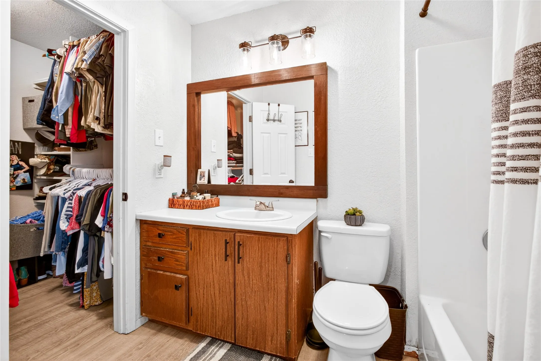 Bathroom featuring a wood-finish vanity with a white countertop and integrated sink