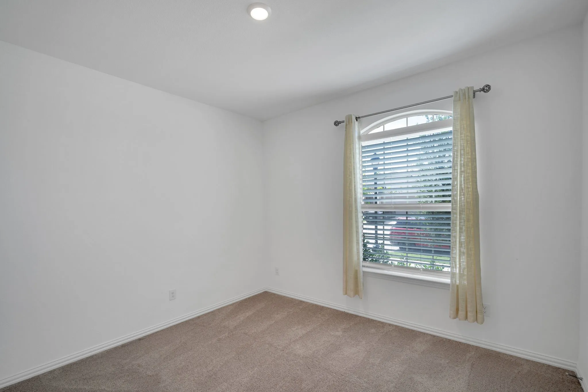 Room featuring light-colored carpeting, white walls, and a recessed ceiling light