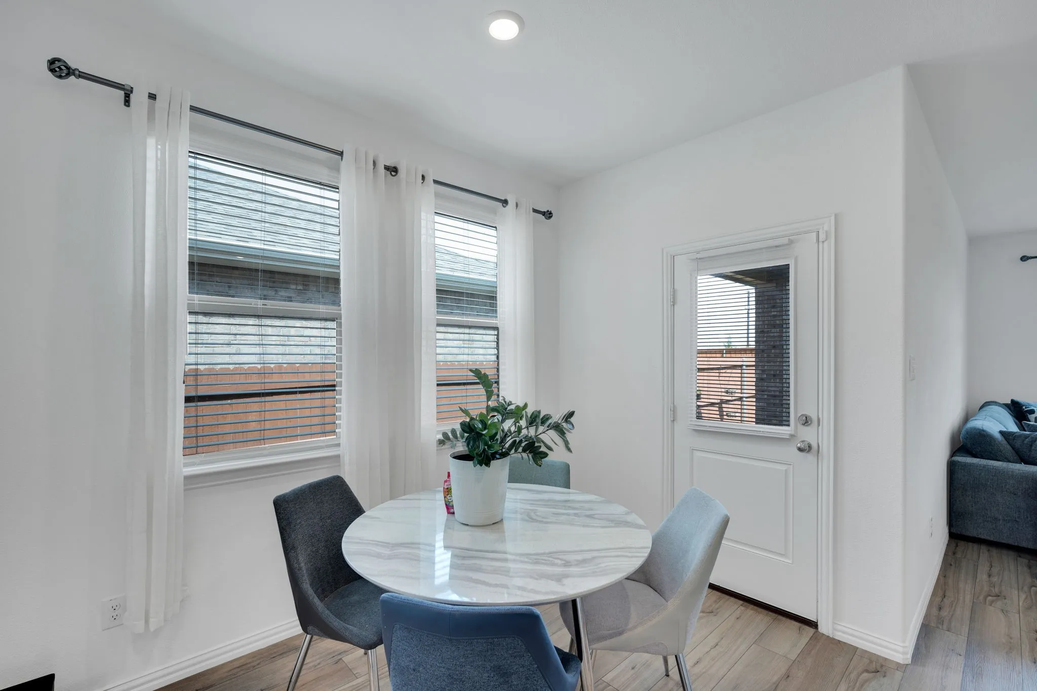 Dedicated dining space featuring wood-finish flooring, white walls, and bright overhead lighting