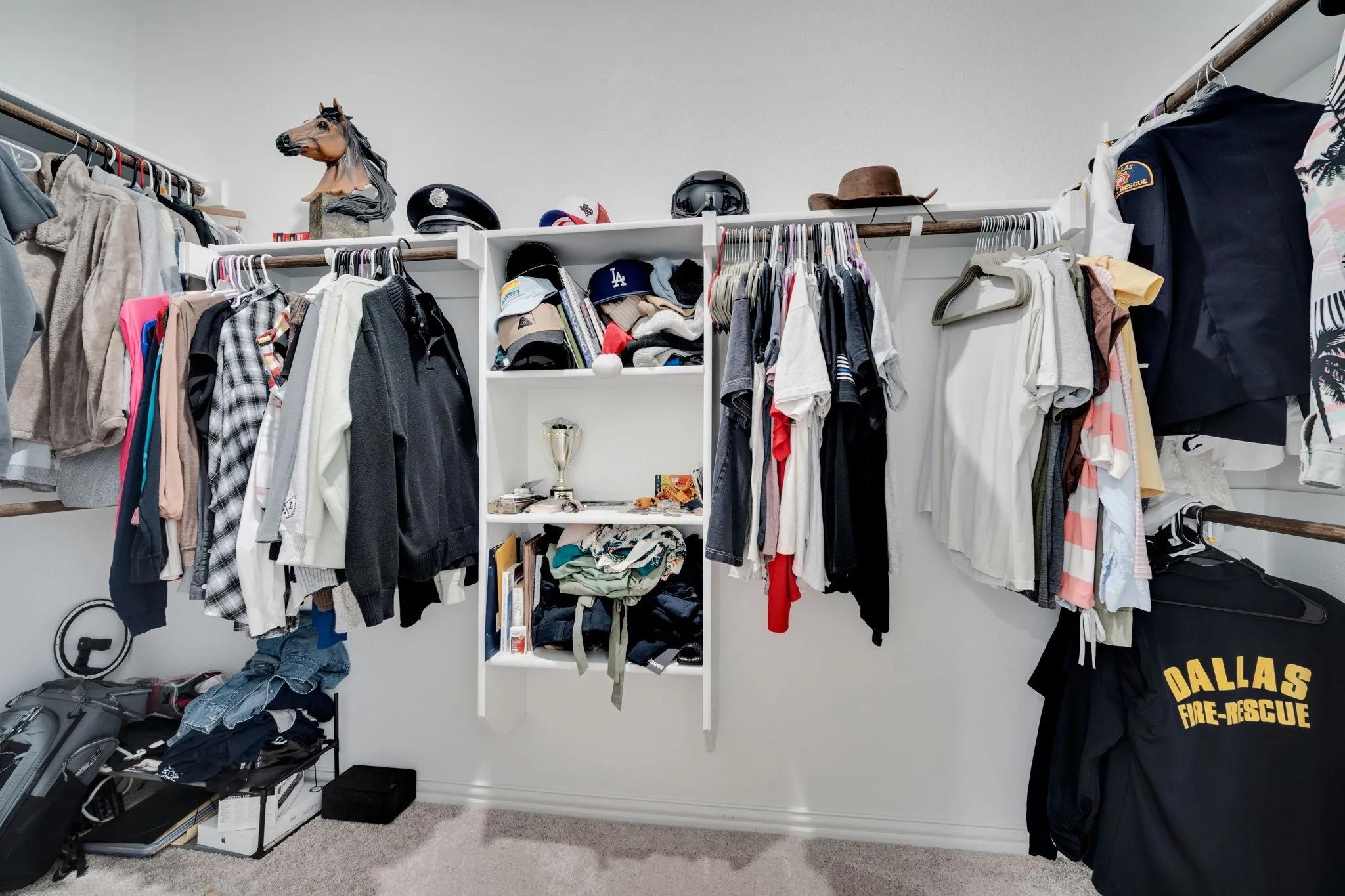 Walk-in closet featuring white walls, light gray carpet, and a custom built-in shelving unit