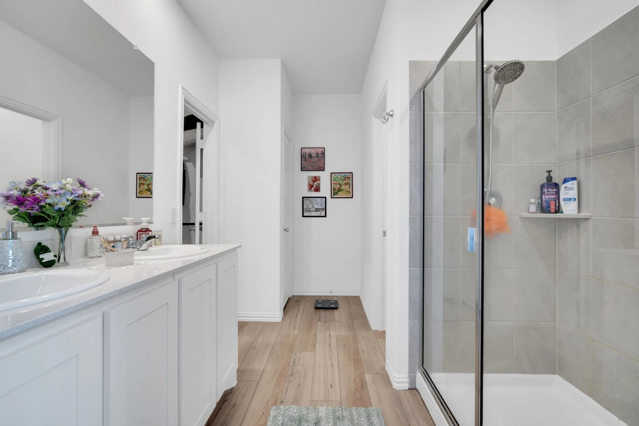 Bathroom featuring a dual vanity with white cabinetry, light-toned countertop, and undermount sinks