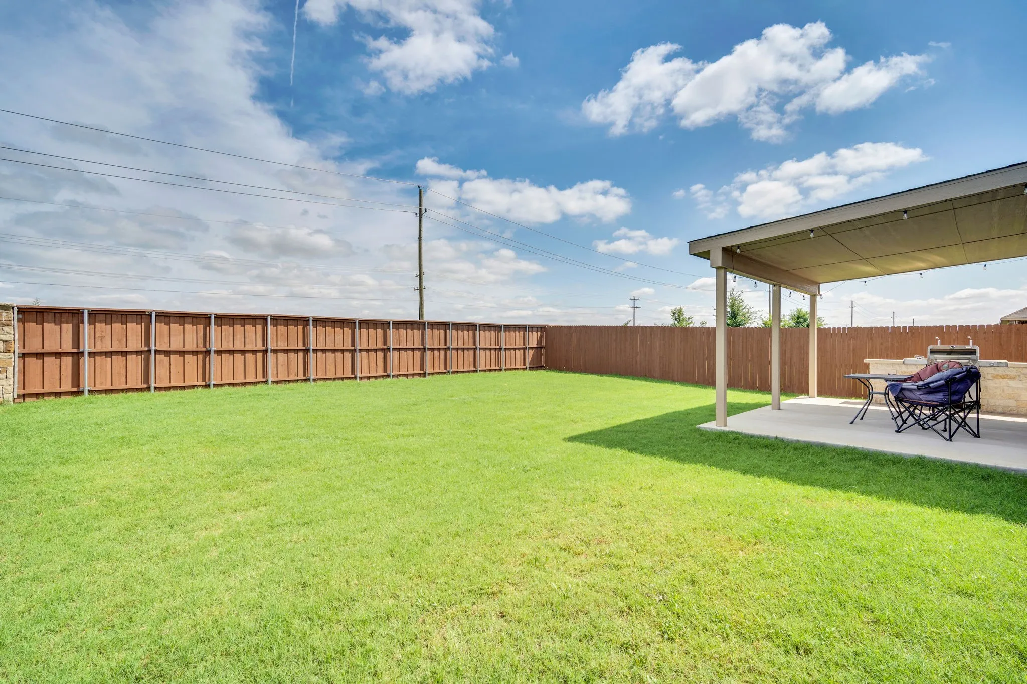 Expansive backyard featuring a lush lawn and a wood privacy fence