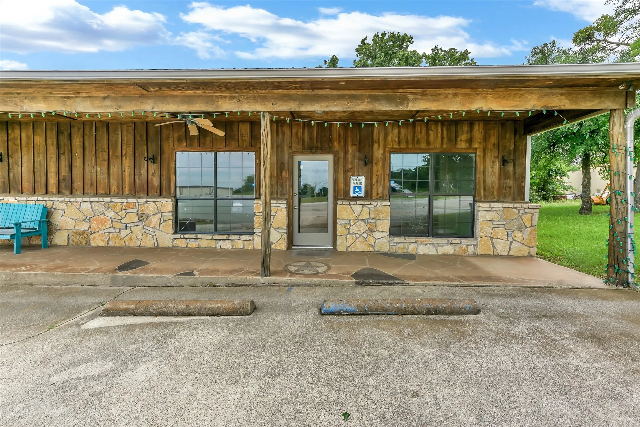 Front exterior showcasing wood-paneled siding and a natural stone wainscot