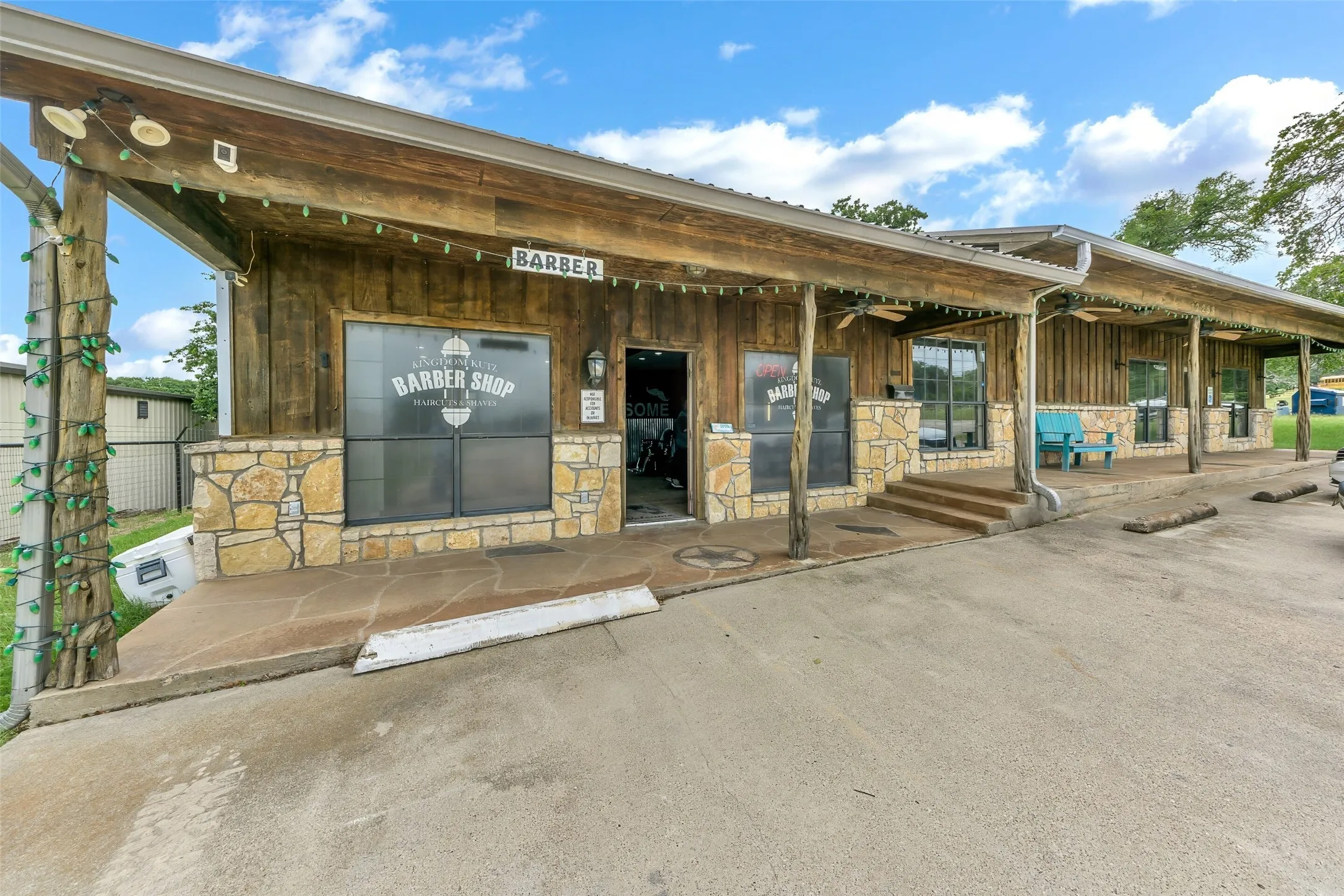 Commercial building featuring wood-paneled siding, stone facade accents, and a covered porch