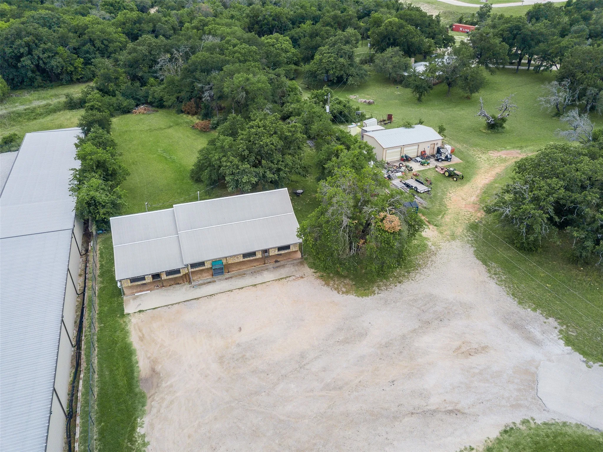 Expansive property featuring multiple structures with metal roofs and a large gravel area