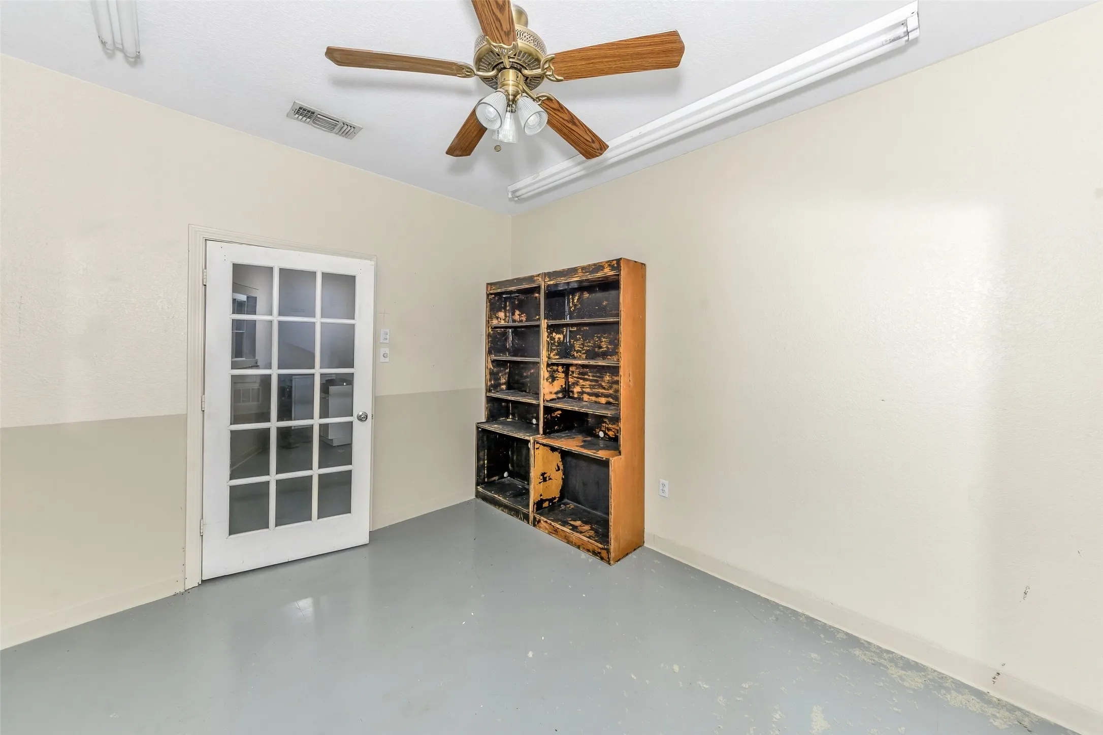 Interior space featuring a white French-pane door, two-tone wall paint, a ceiling fan with light fixture, and track lighting