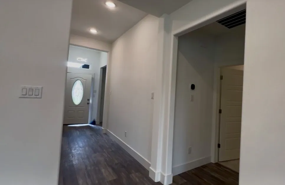 Entryway featuring wood-finish flooring, recessed lighting, white trim, and a front door with an oval glass insert