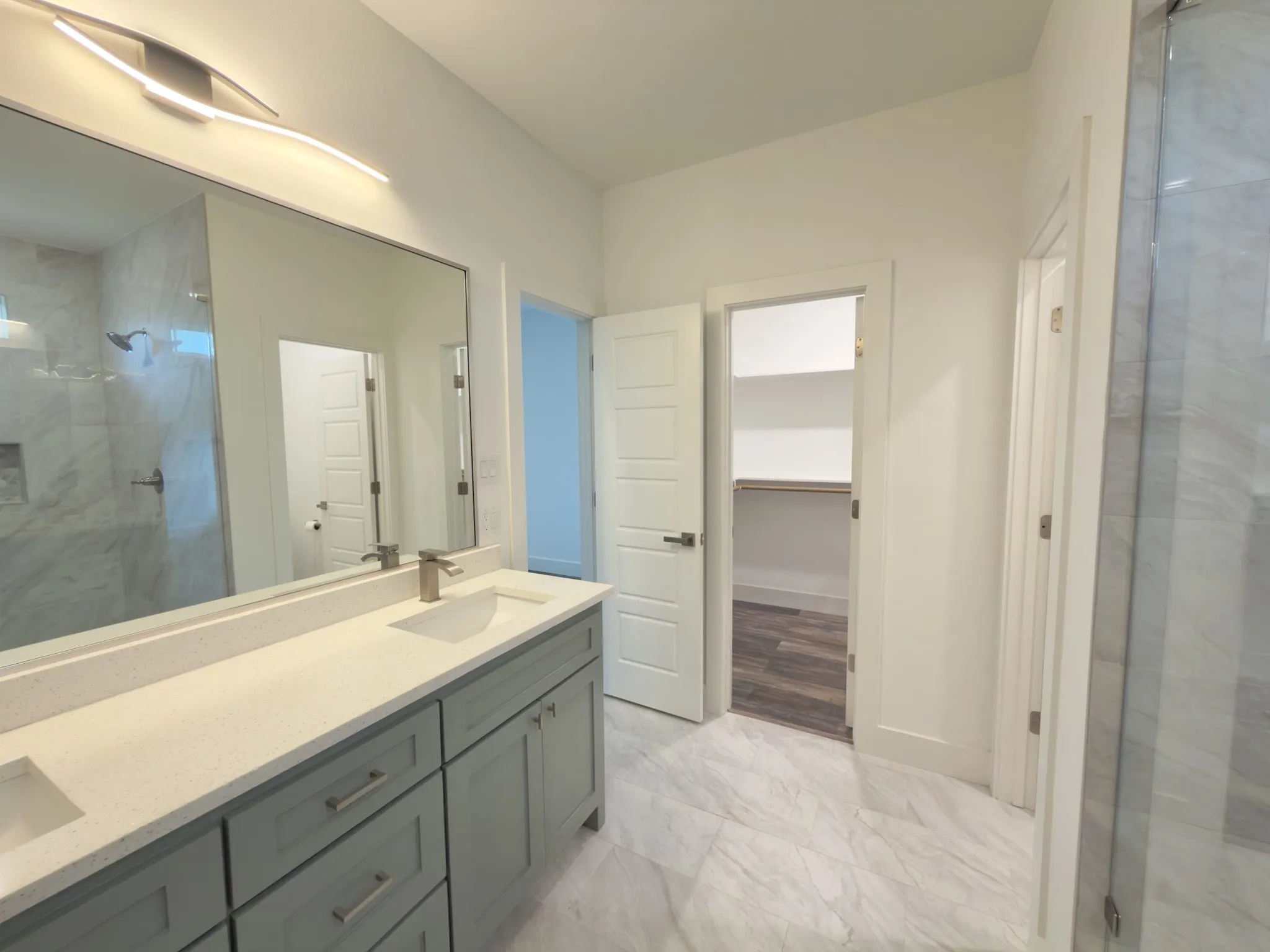 Bathroom featuring a double vanity with light gray cabinetry and light-toned countertops